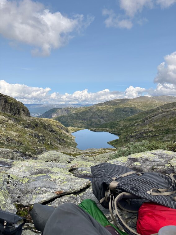 View of still lake with backpack and part of lake in the foreground