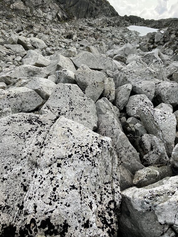 Black and white stones with a small snowfield in the background